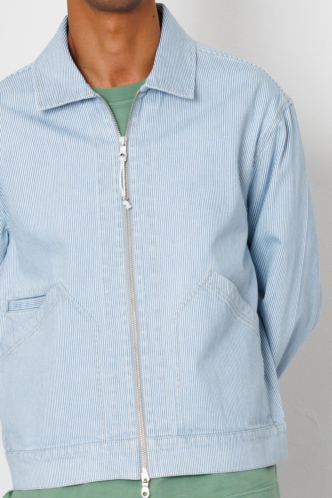 Light blue corduroy jacket with a zipper on a neutral background