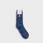 A single blue marled crew sock with a small orange and white mountain graphic near the cuff, shown against a light gray background.