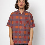 Man wearing a plaid shirt against a white background