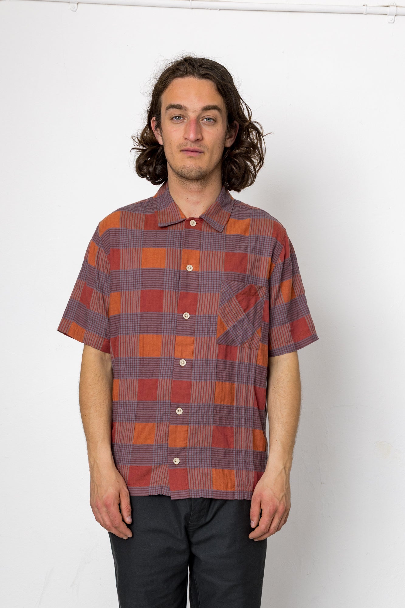 Man wearing a plaid shirt against a white background