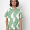 Man wearing a green and white patterned shirt against a white background
