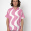Person wearing a pink shirt with white wavy pattern on a white background
