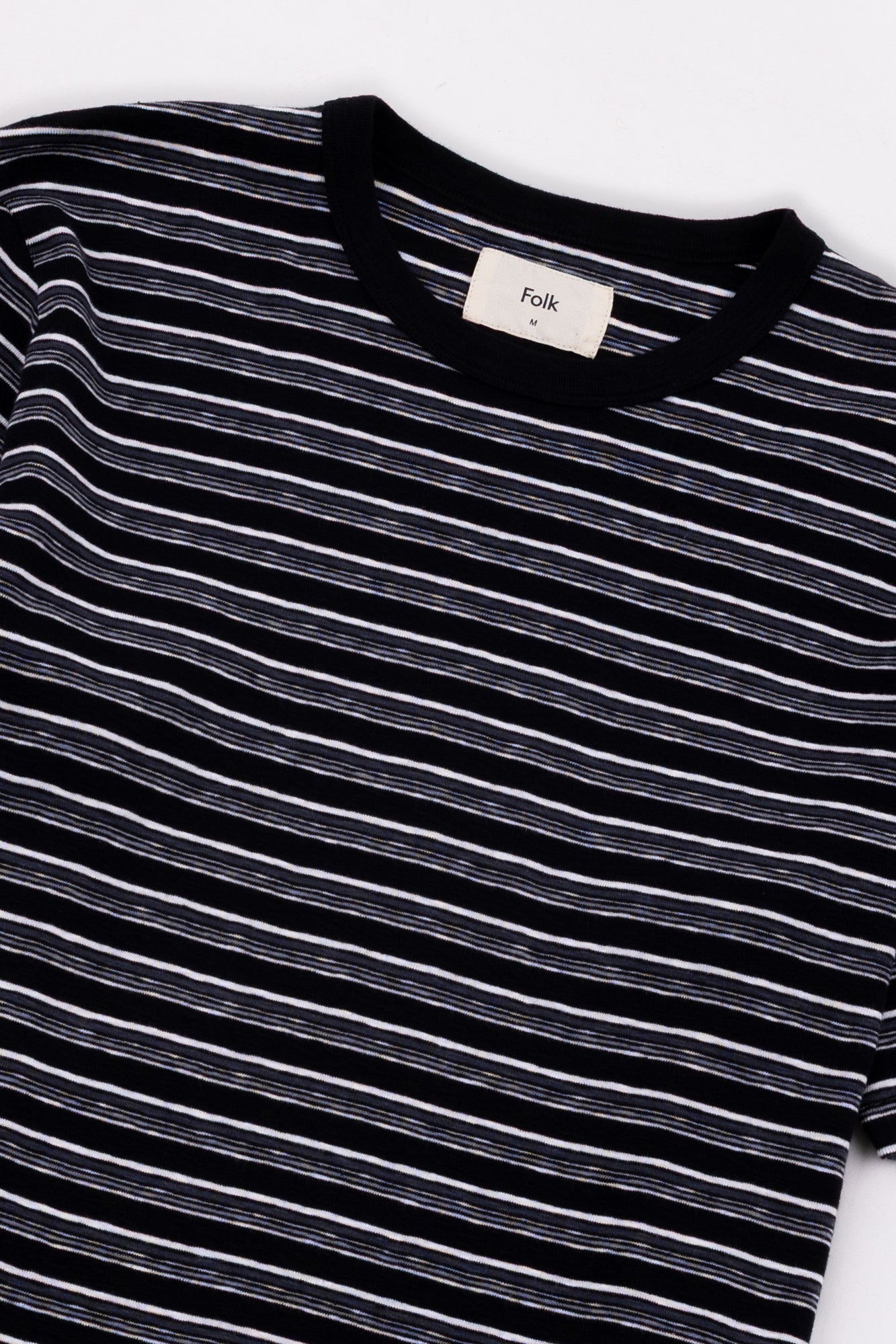 Black and white striped shirt with a visible brand label on a white background