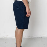 Person wearing navy shorts and black sneakers on a white background