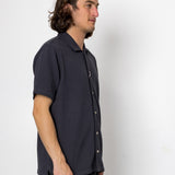 Man wearing a dark blue shirt against a white background
