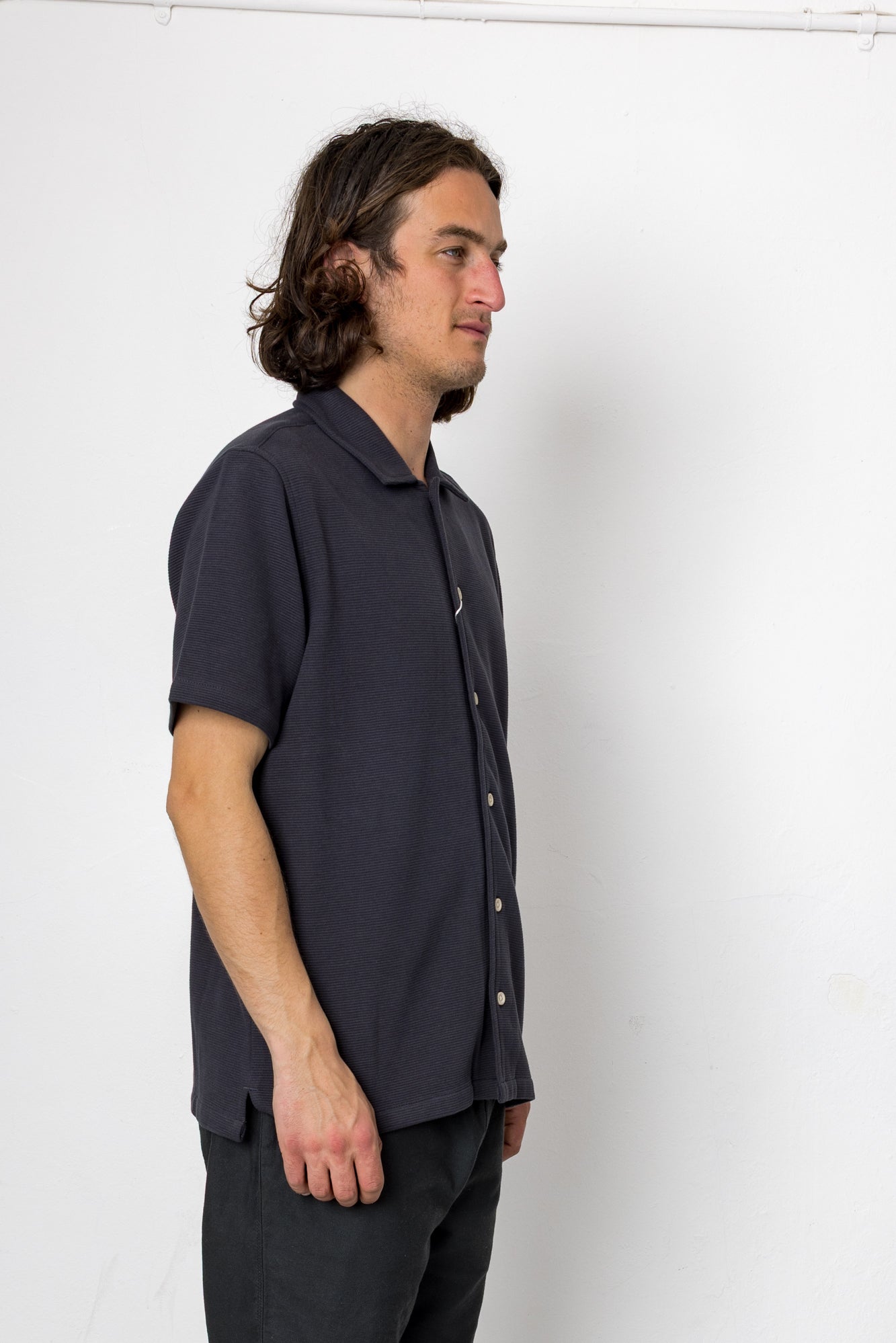 Man wearing a dark blue shirt against a white background
