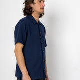 Man wearing a navy blue shirt against a white background
