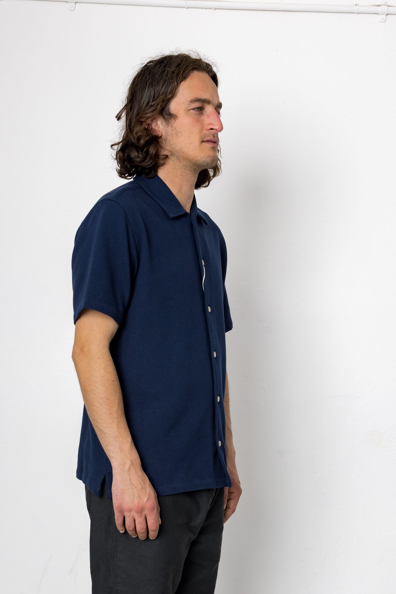 Man wearing a navy blue shirt against a white background