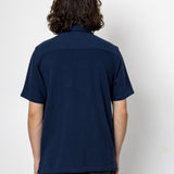 Person wearing a navy blue shirt against a white background