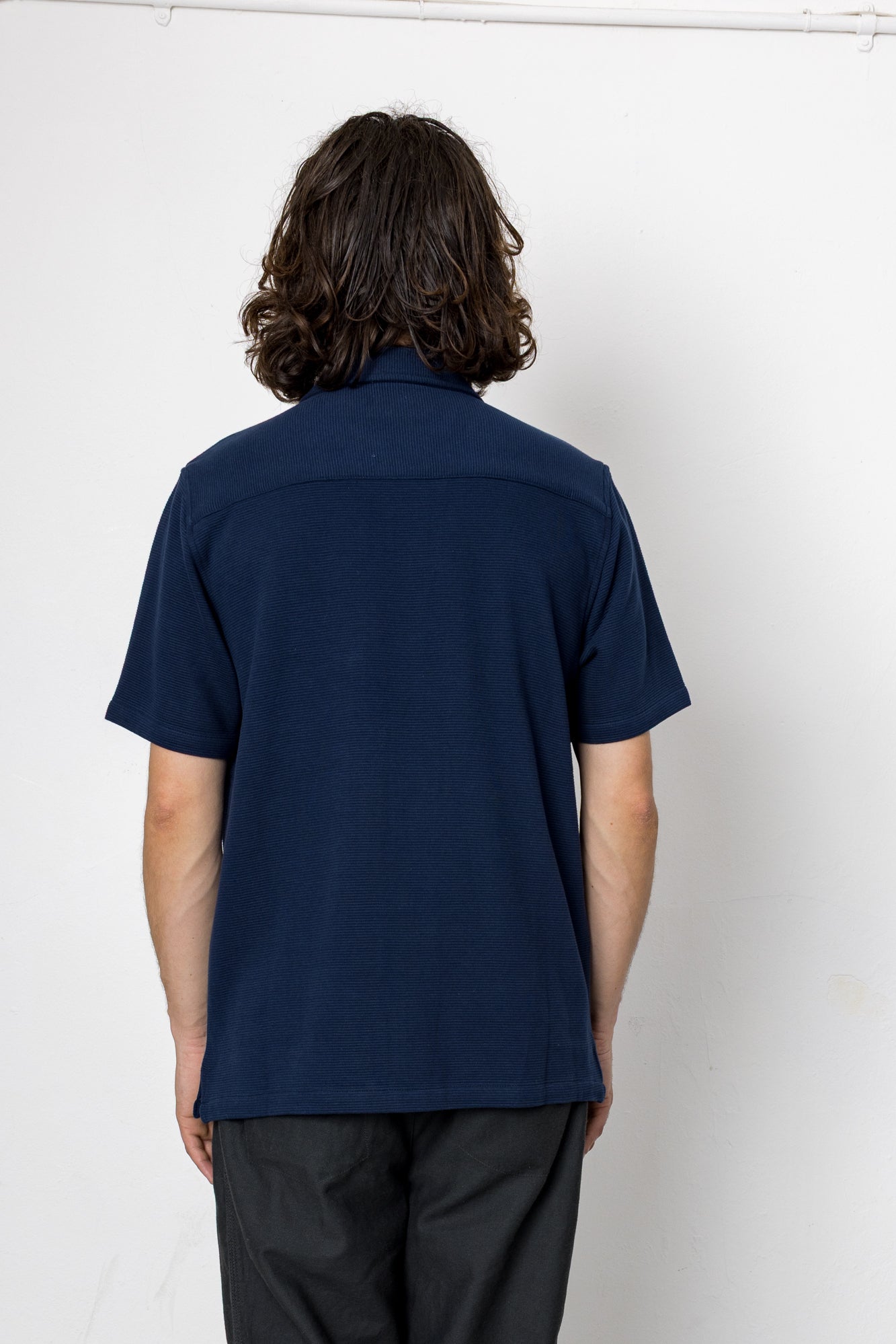 Person wearing a navy blue shirt against a white background