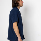 Man wearing a navy blue shirt against a white background