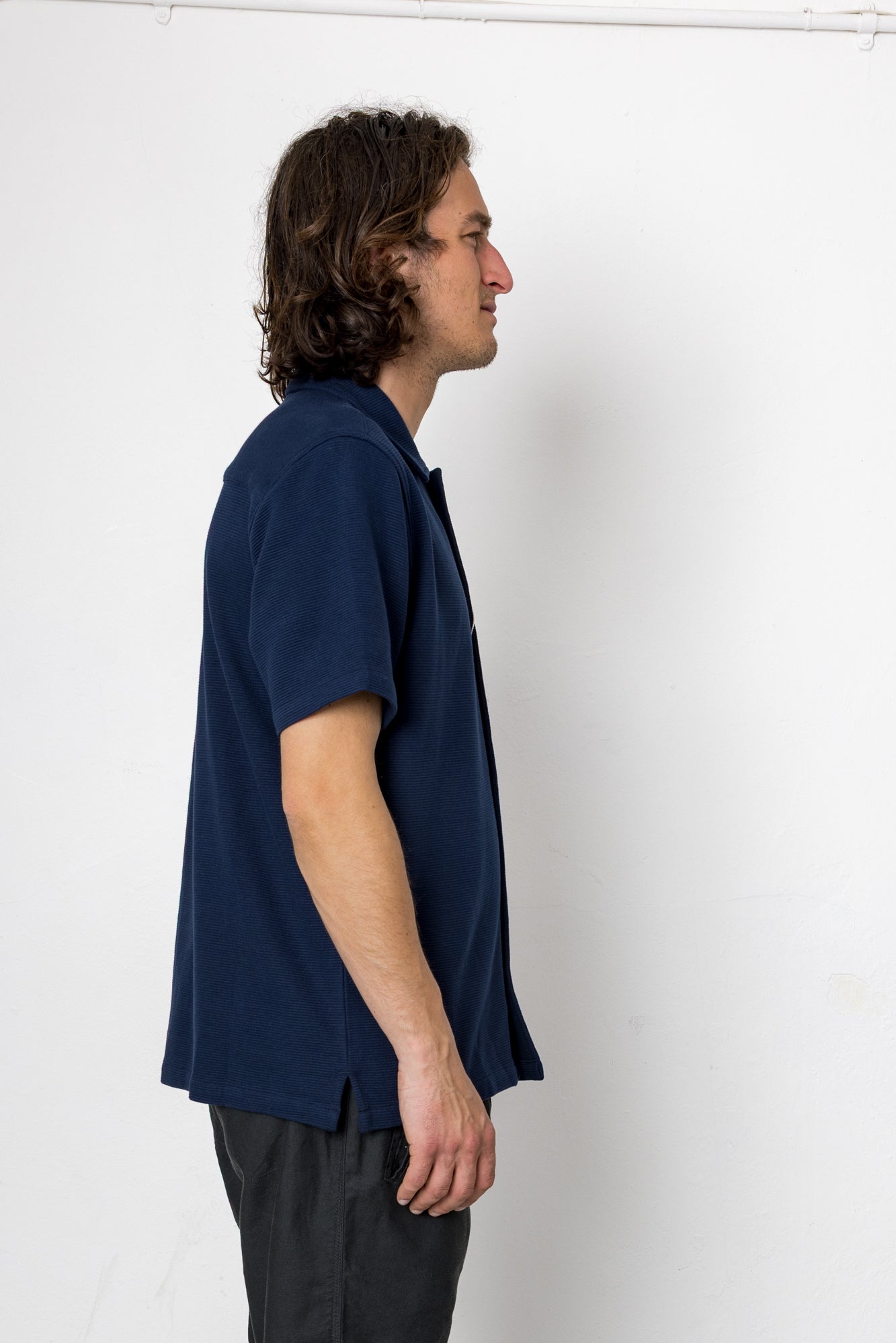 Man wearing a navy blue shirt against a white background