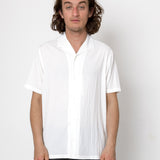 Man wearing a white shirt against a plain background