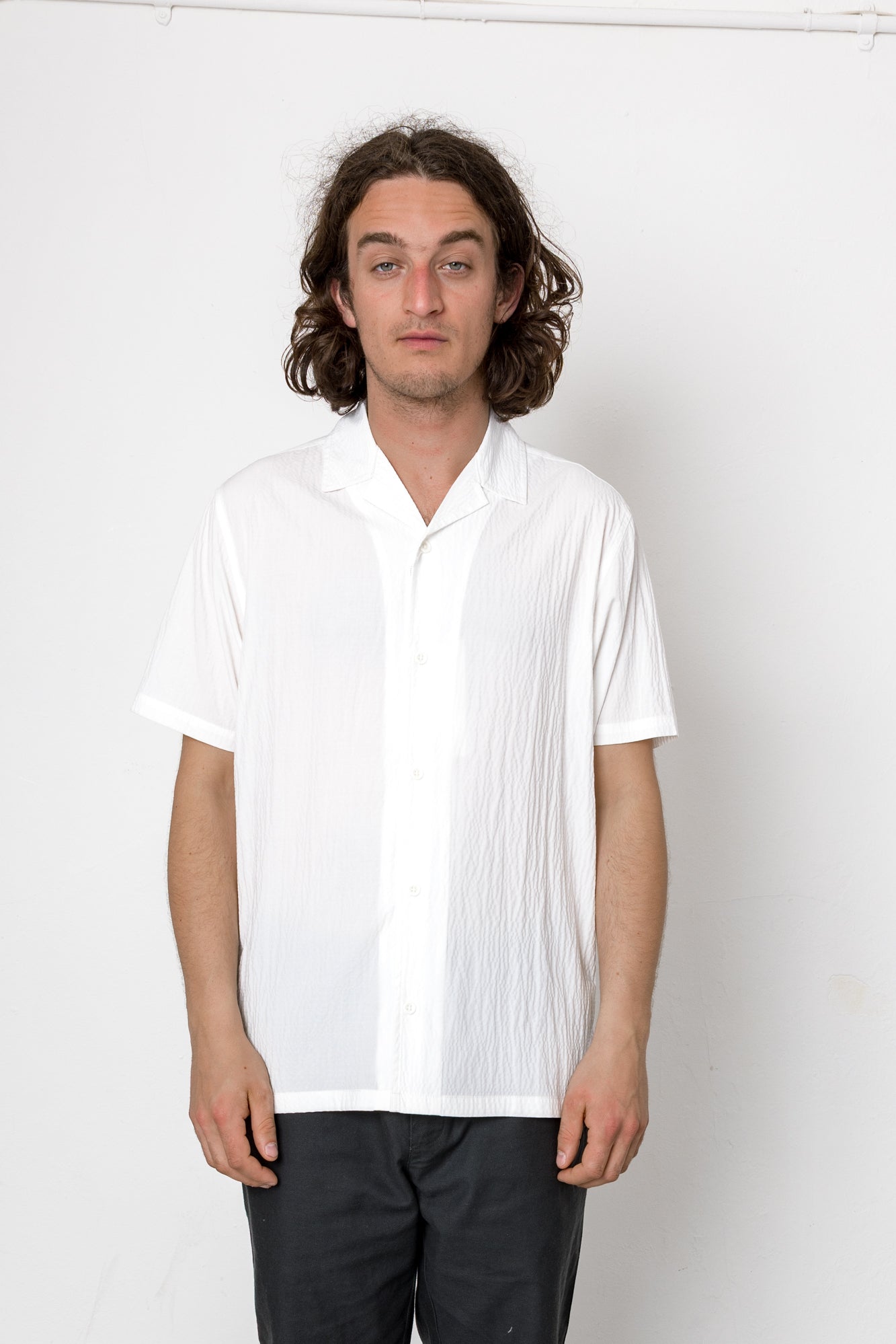 Man wearing a white shirt against a plain background