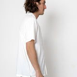 Person wearing a white t-shirt and black pants against a white background