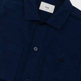 Navy overshirt with a visible brand label on a light gray background