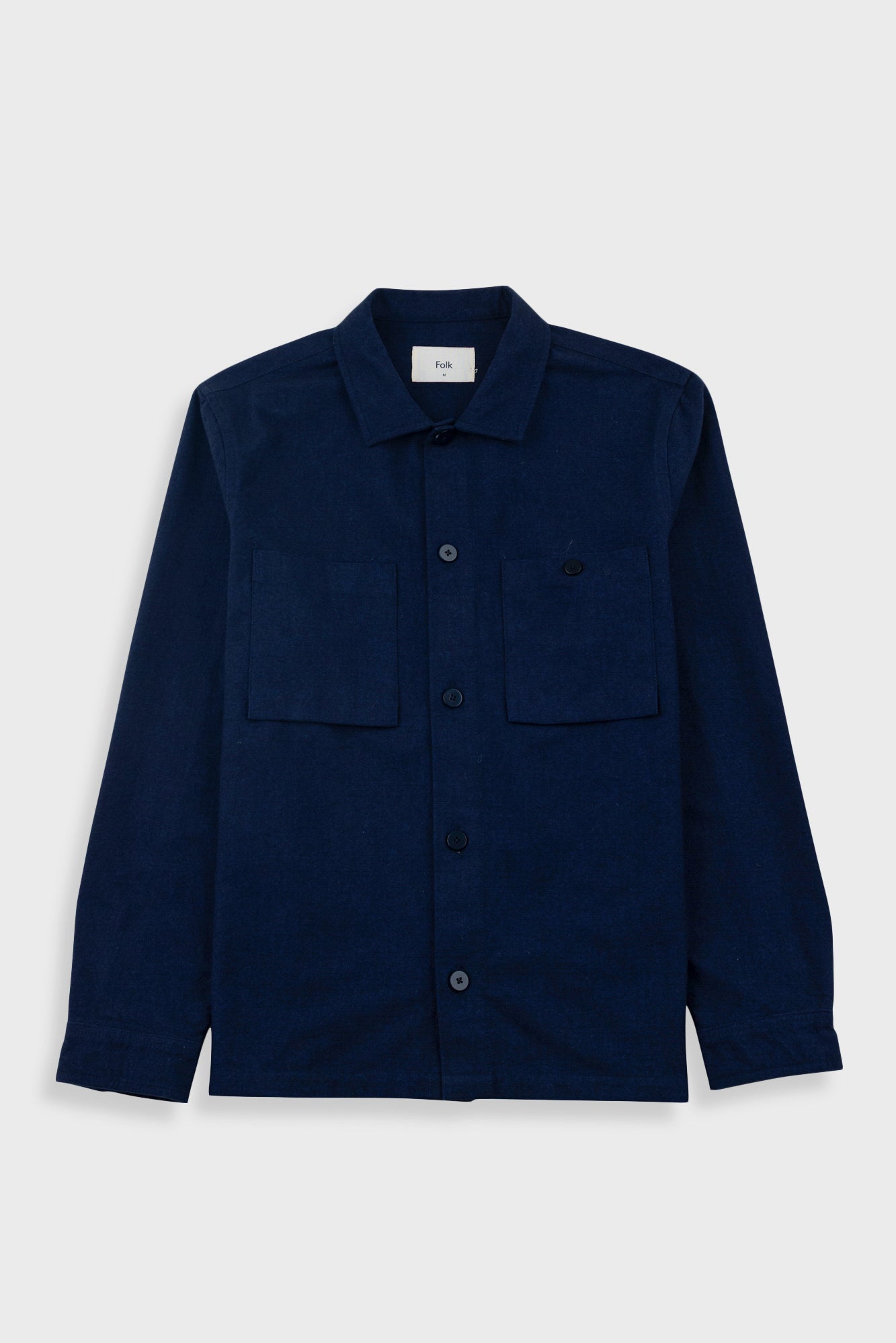 Navy overshirt with a visible brand label on a light gray background