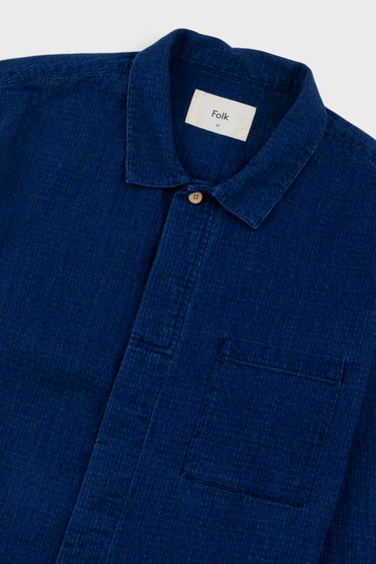 Blue shirt with a collar and pocket, featuring the brand 'Folk' on a white background.