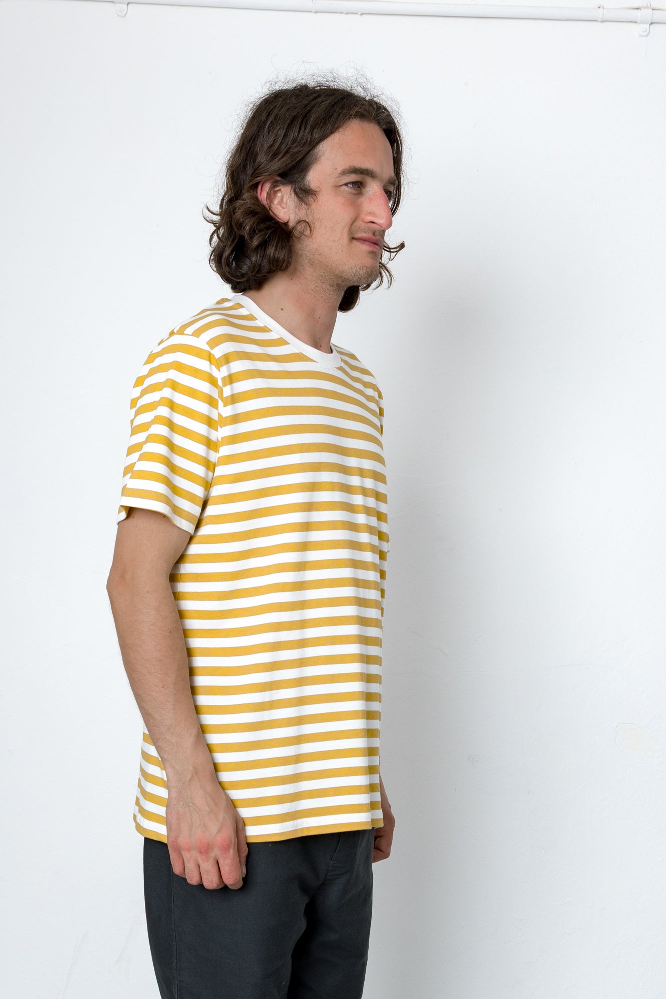 Man wearing a yellow and white striped shirt against a white background