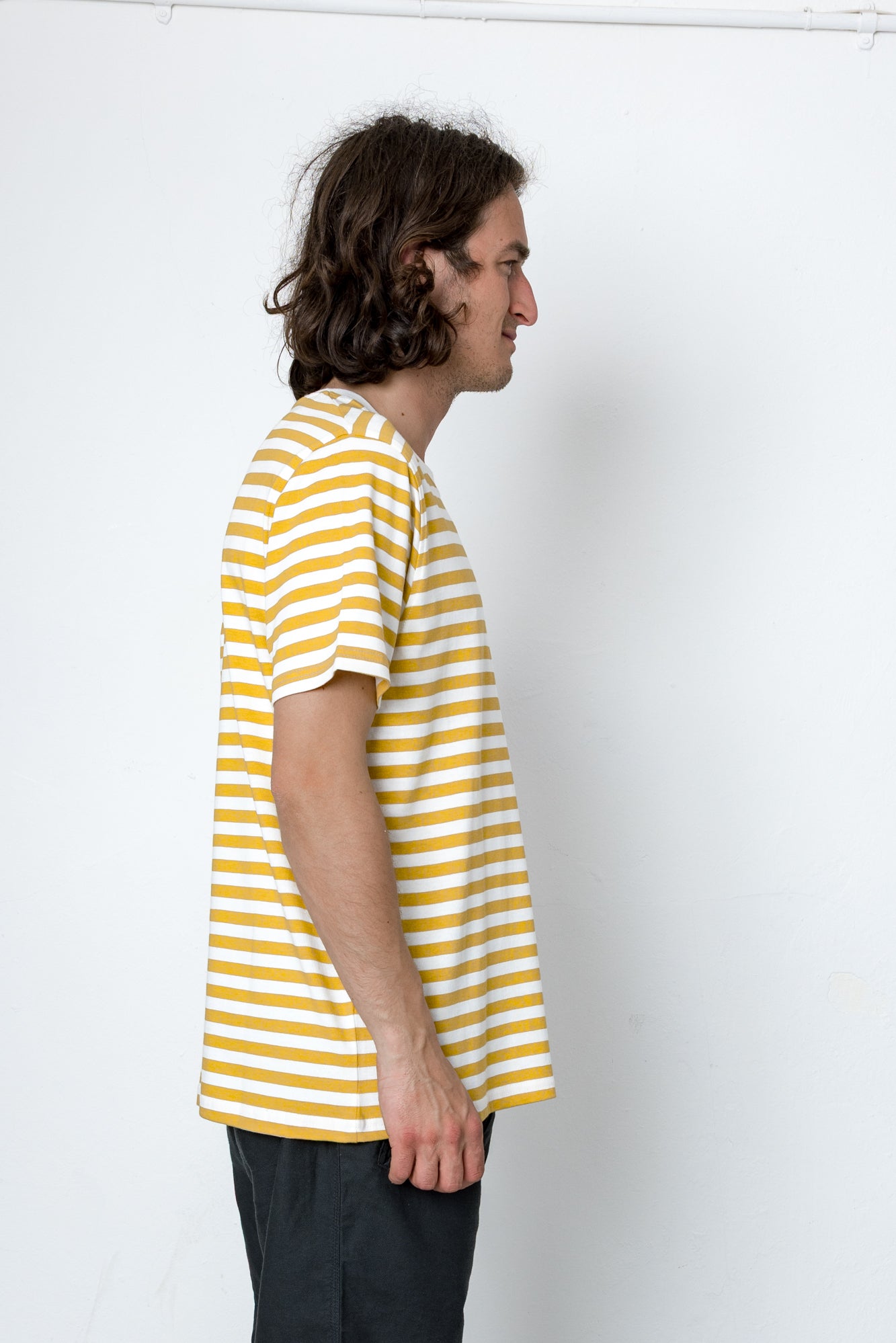 Person wearing a yellow and white striped shirt against a white background