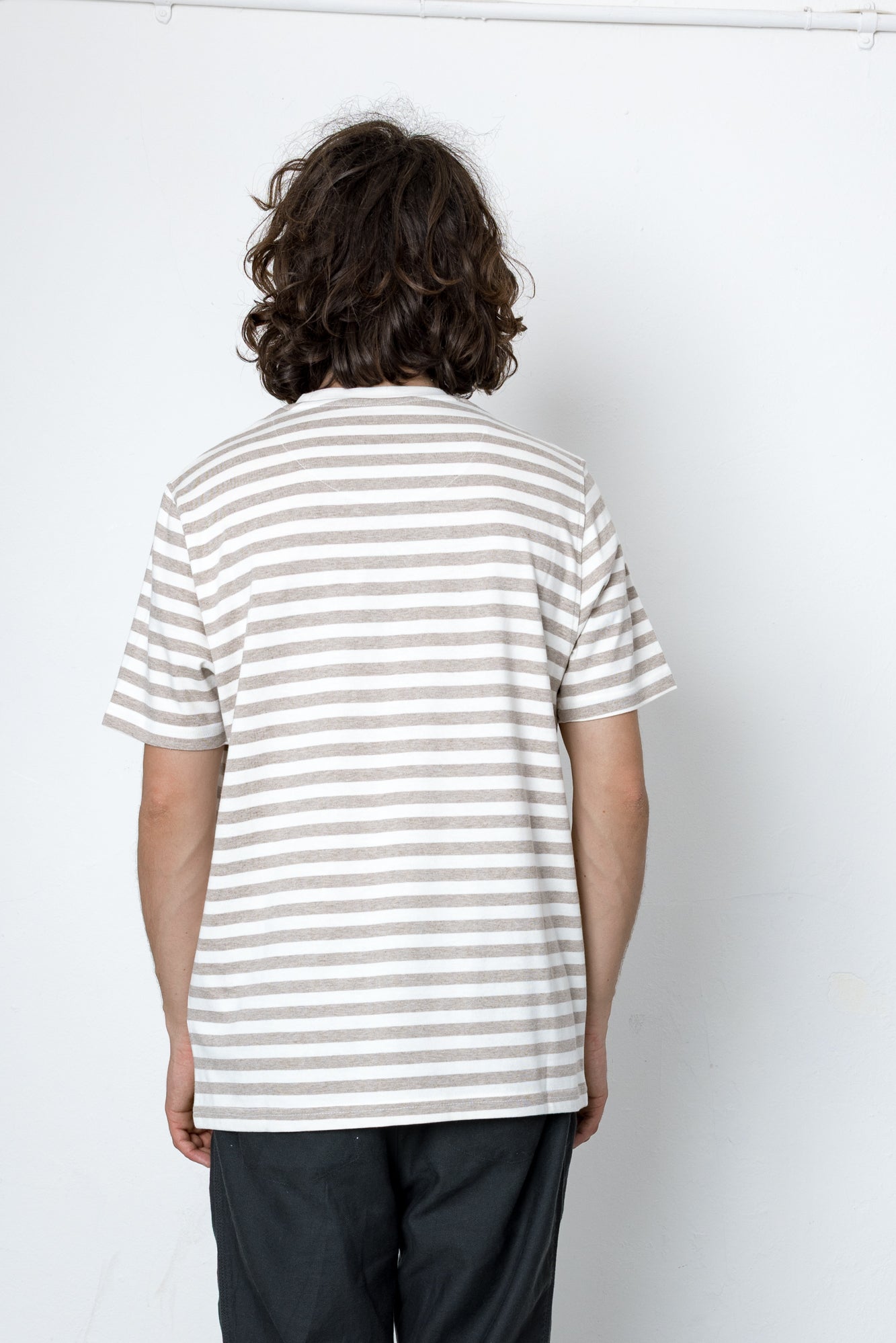 Person wearing a striped shirt from behind on a white background