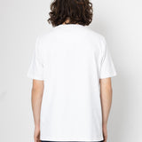 Person wearing a plain white t-shirt and dark jeans on a light gray background