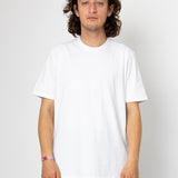 Man wearing a plain white t-shirt against a white background