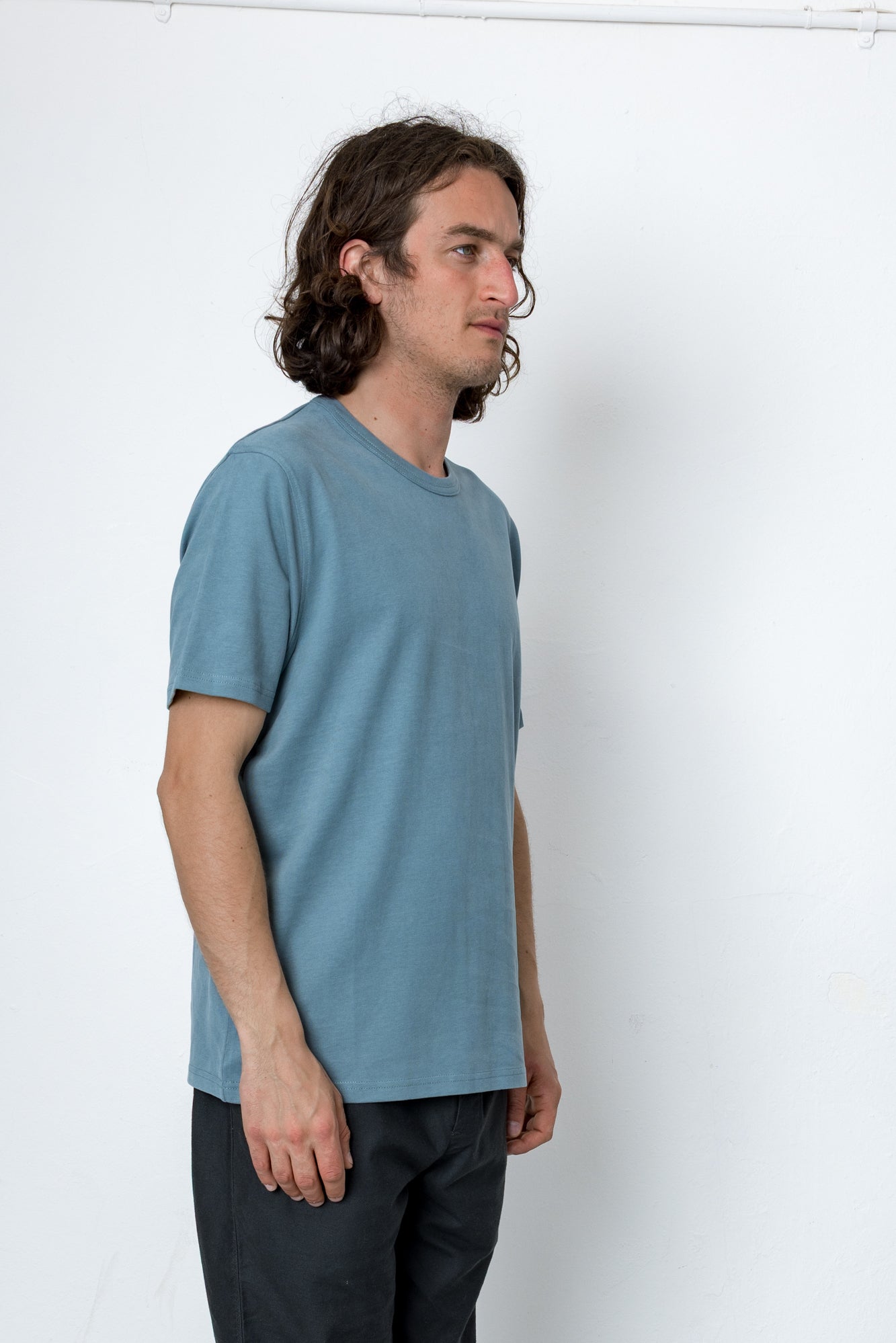 Man wearing a blue t-shirt against a white background