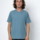 Person wearing light blue t-shirt and dark trousers