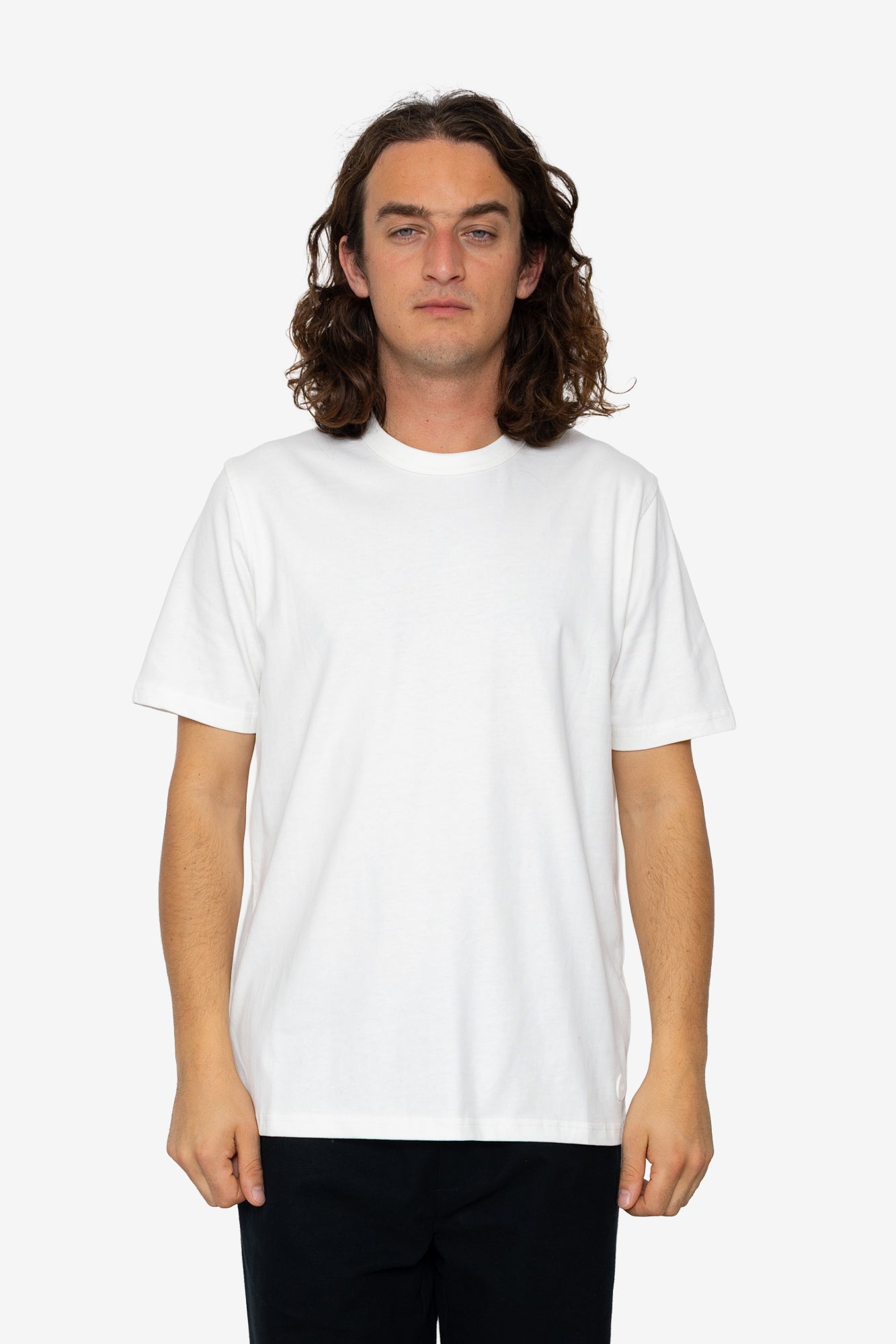 Person wearing a plain white t-shirt on a white background