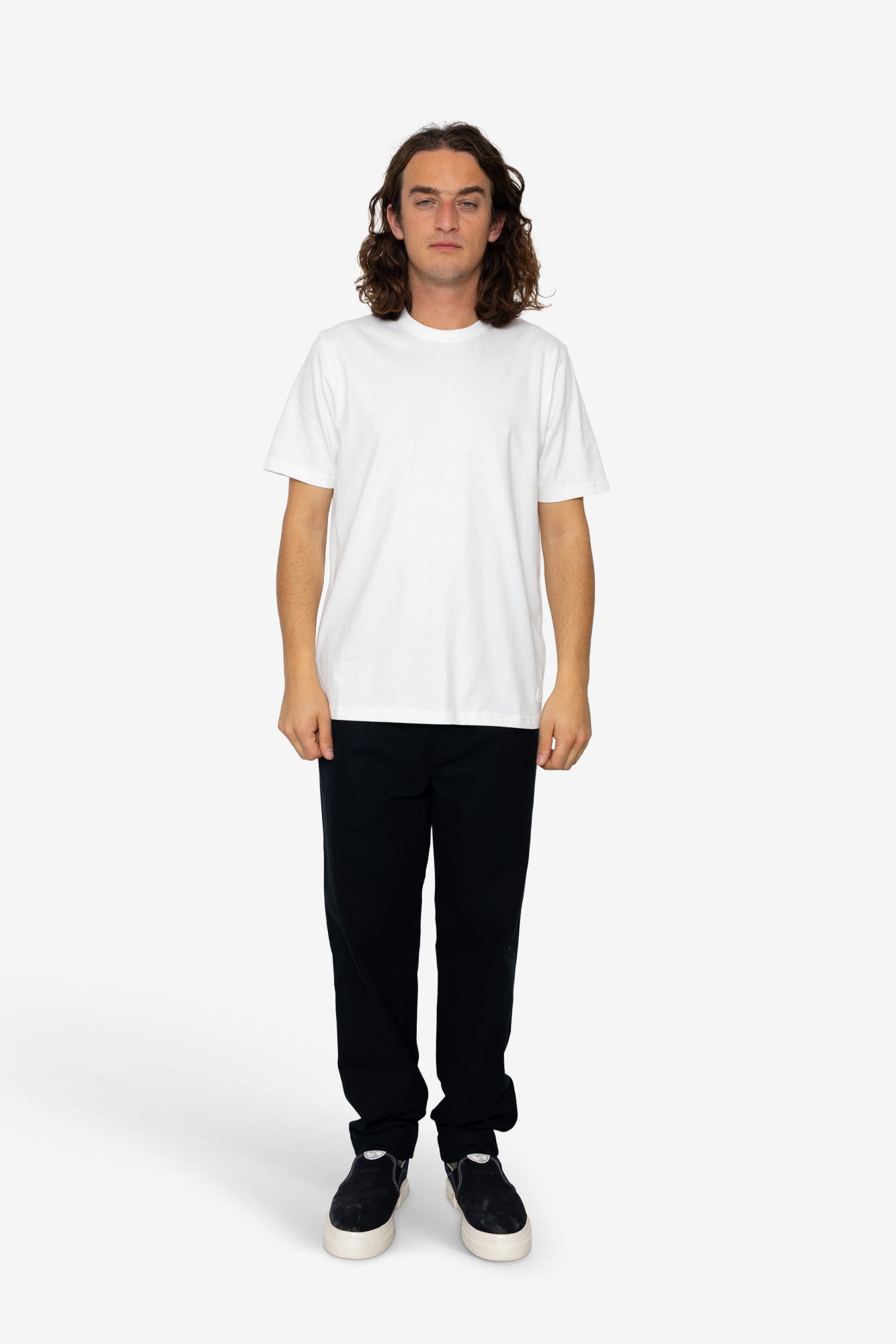 Person wearing a white t-shirt and black pants on a white background