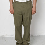 Person wearing olive green pants and black shoes against a white background