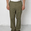 Person wearing olive green pants and black shoes against a white background