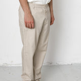 Person wearing beige pants and black shoes on a white background