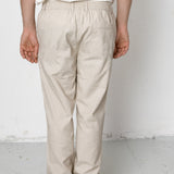 Person wearing beige pants and black sneakers on a white background