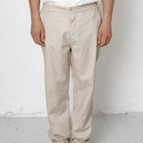 Person wearing beige pants and black shoes on a white background