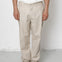 Person wearing beige pants and black shoes on a white background