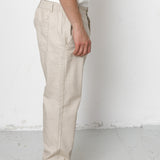 Person wearing beige pants and black shoes on a white background