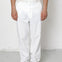 Person wearing white pants and black shoes on a plain background