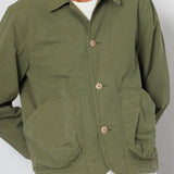 Green jacket worn by a person on a plain background