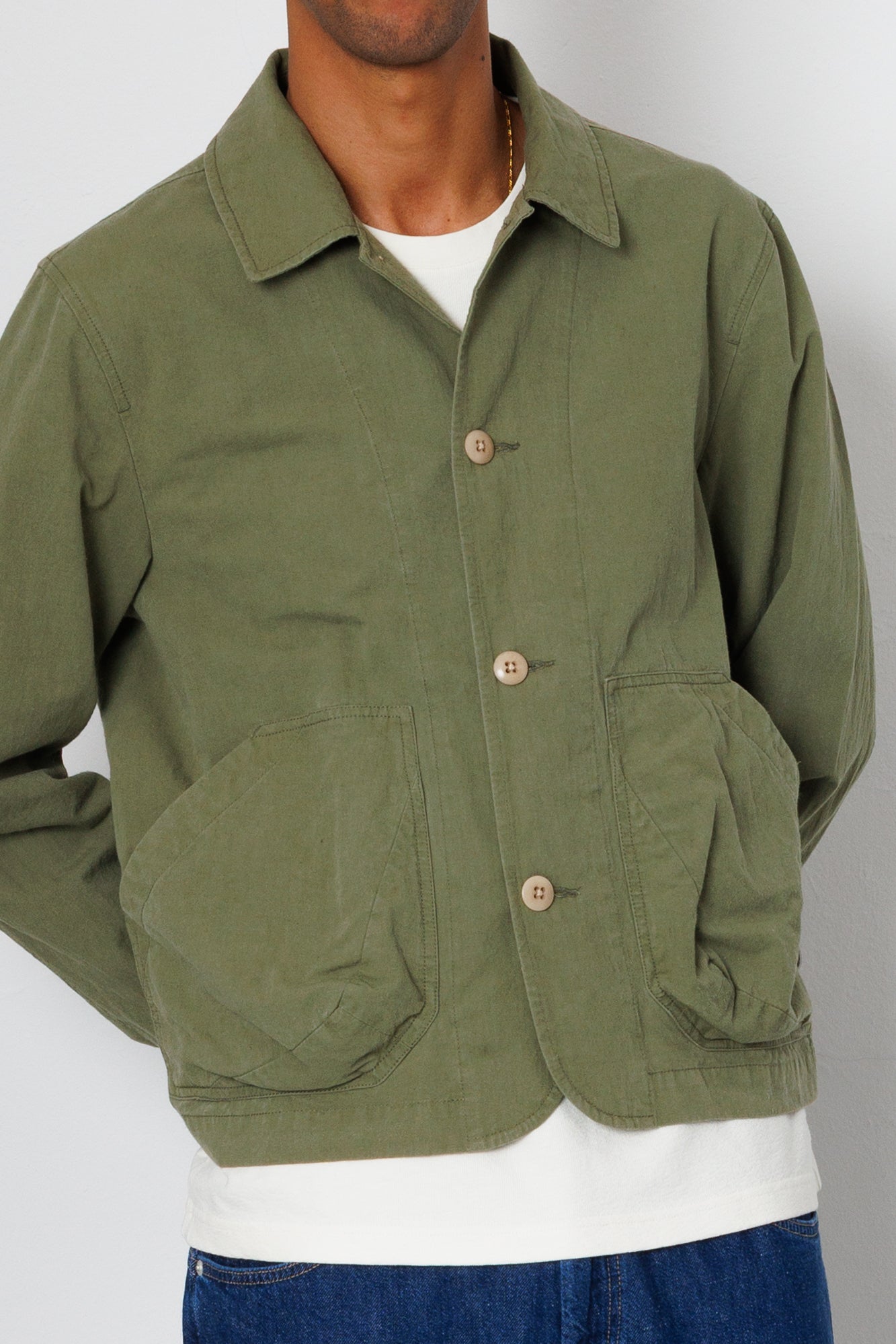 Green jacket worn by a person on a plain background