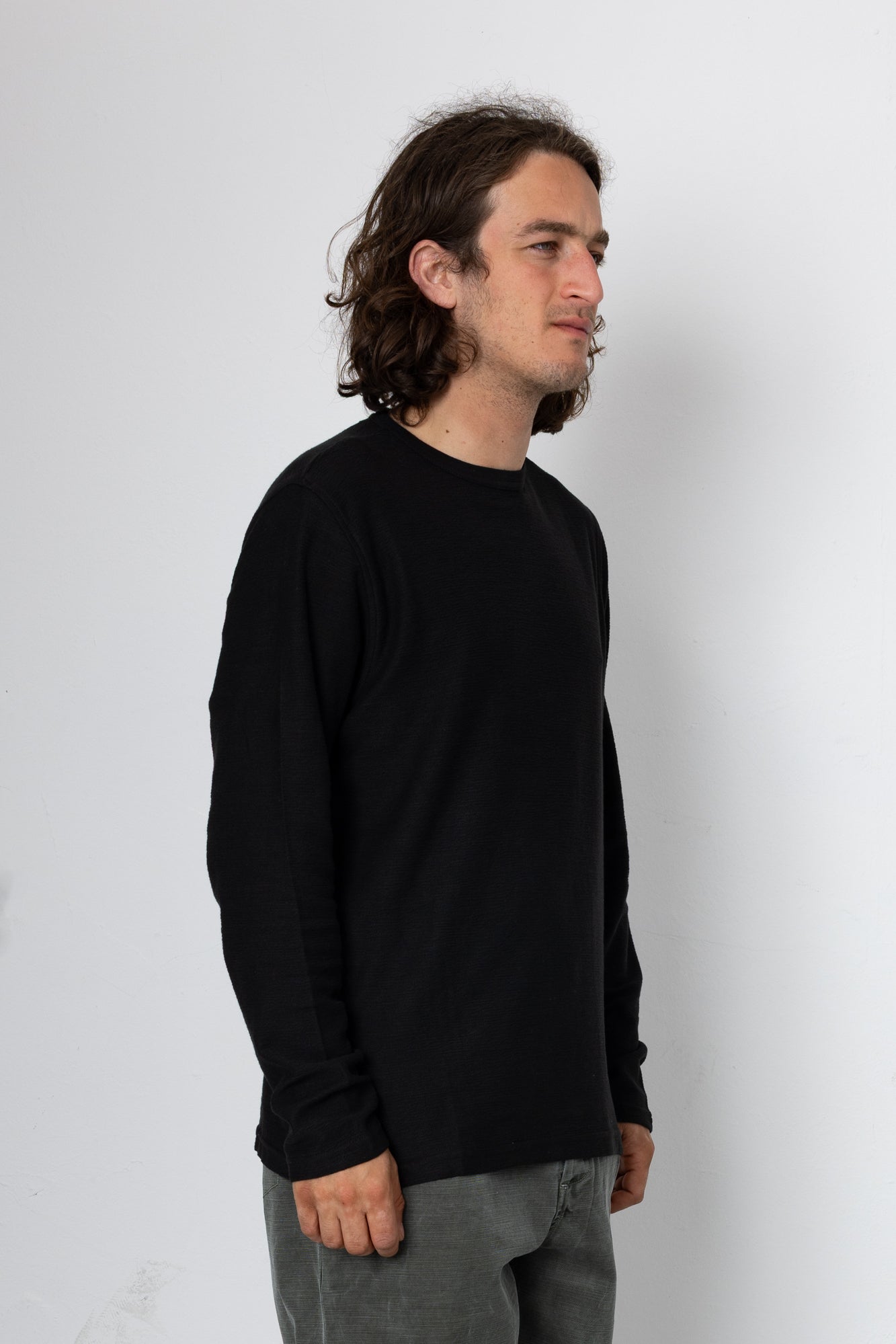 Man wearing a black long-sleeve shirt against a white background