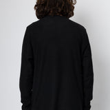 Person wearing a black long-sleeve shirt against a white background