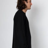 Person wearing a black long-sleeve shirt against a white background