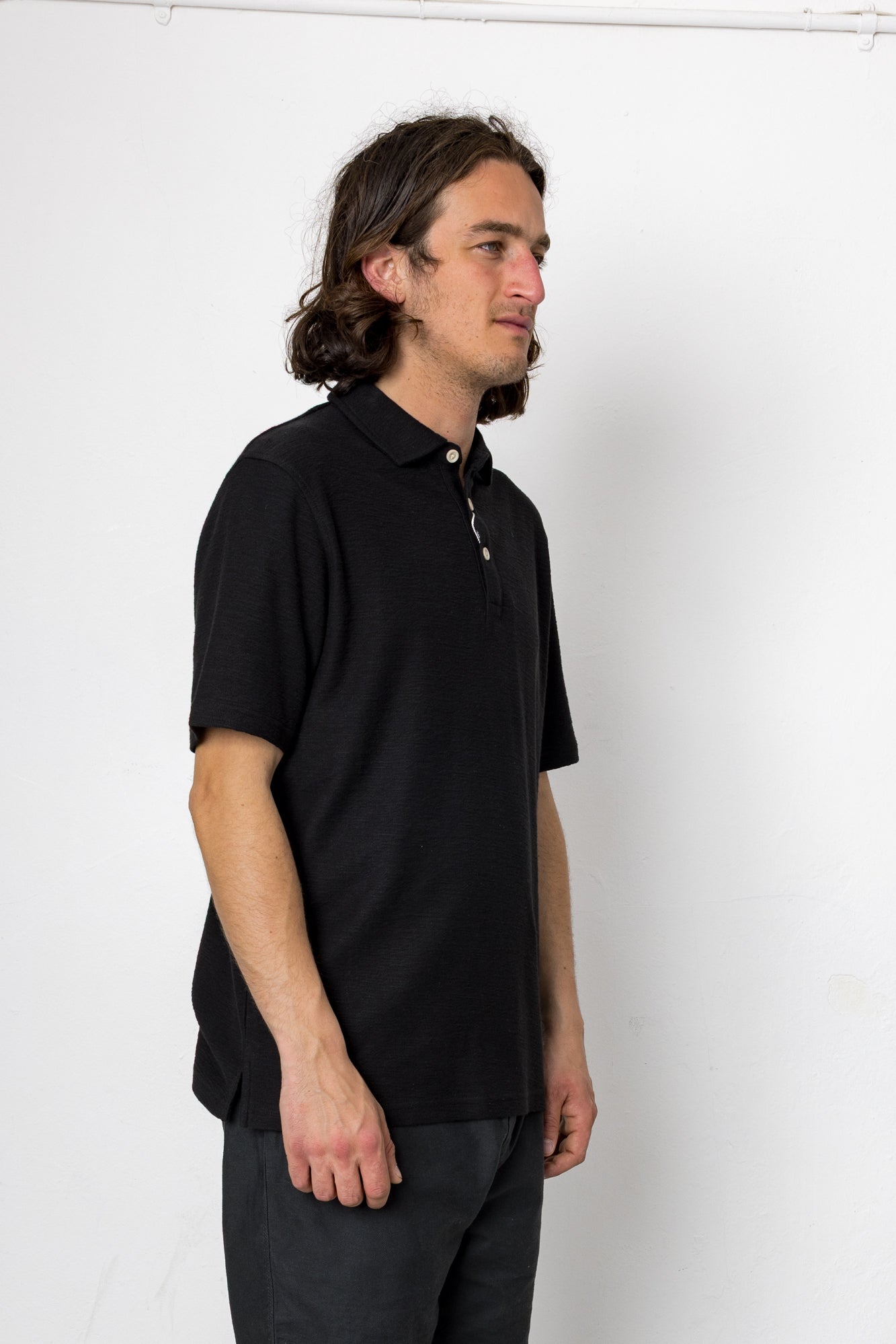 Man wearing a black polo shirt against a white background