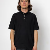 Man wearing a black polo shirt against a white background