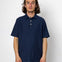 Person wearing a navy blue polo shirt against a white background