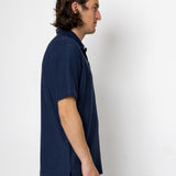 Man wearing a navy blue shirt against a white background