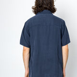 Person wearing a navy blue short-sleeve shirt on a white background