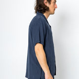 Man wearing a navy blue shirt against a white background